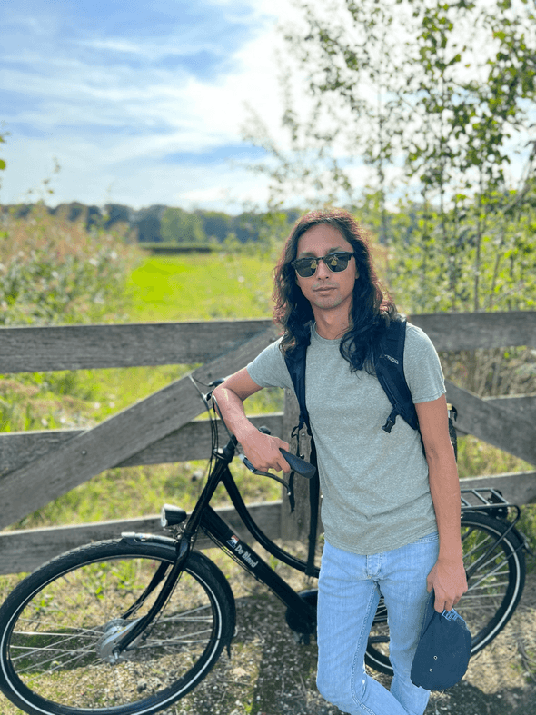 Joey posing with a bike in the Dutch countryside.
